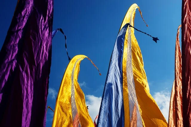 Traditional Balinese flags with silver stripes fluttering in wind for ceremonies.
