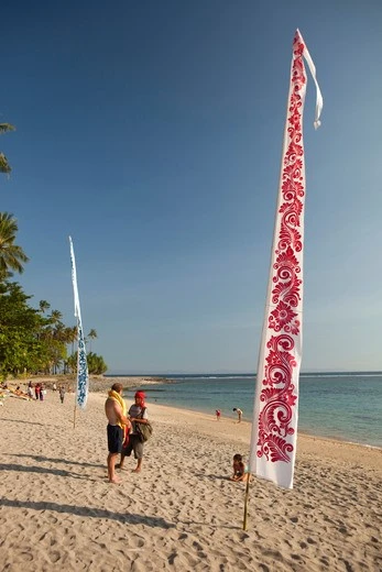 White and blue Bali banners on tropical beach, ideal for resort decor and promotions.