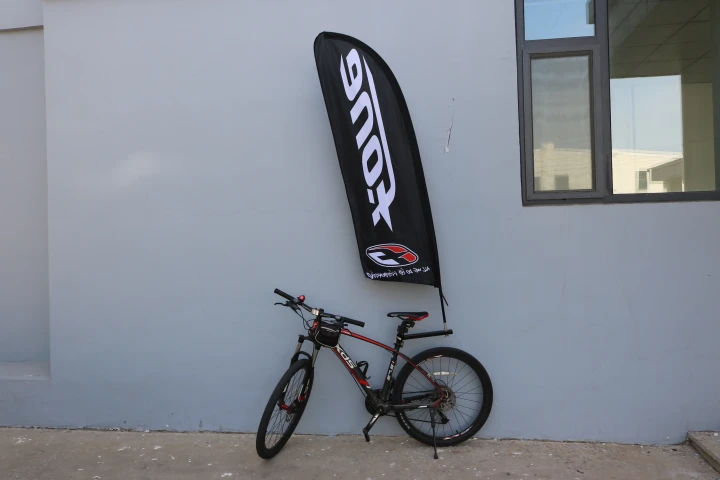 bike flag bracket mounted on XDS mountain bike with black-red frame Red-black mountain bike with WZRODS branded safety bike flag against grey wall background