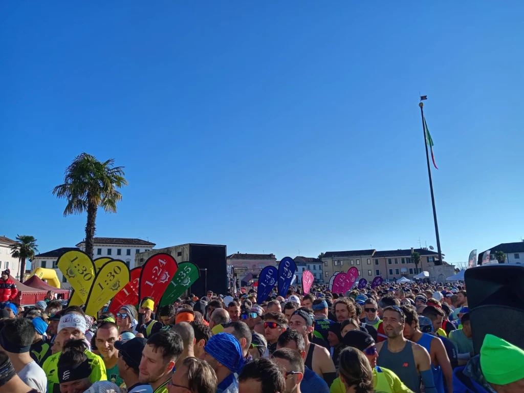 Grupo de corredores com bandeiras coloridas de ritmo, incluindo vários com mochilas WZRODS para pacers