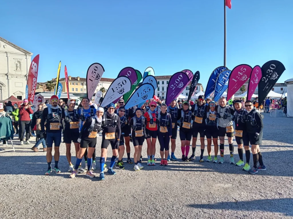 Equipa de pacers com mochilas WZRODS para maratona e várias bandeiras de ritmo ao longo do percurso