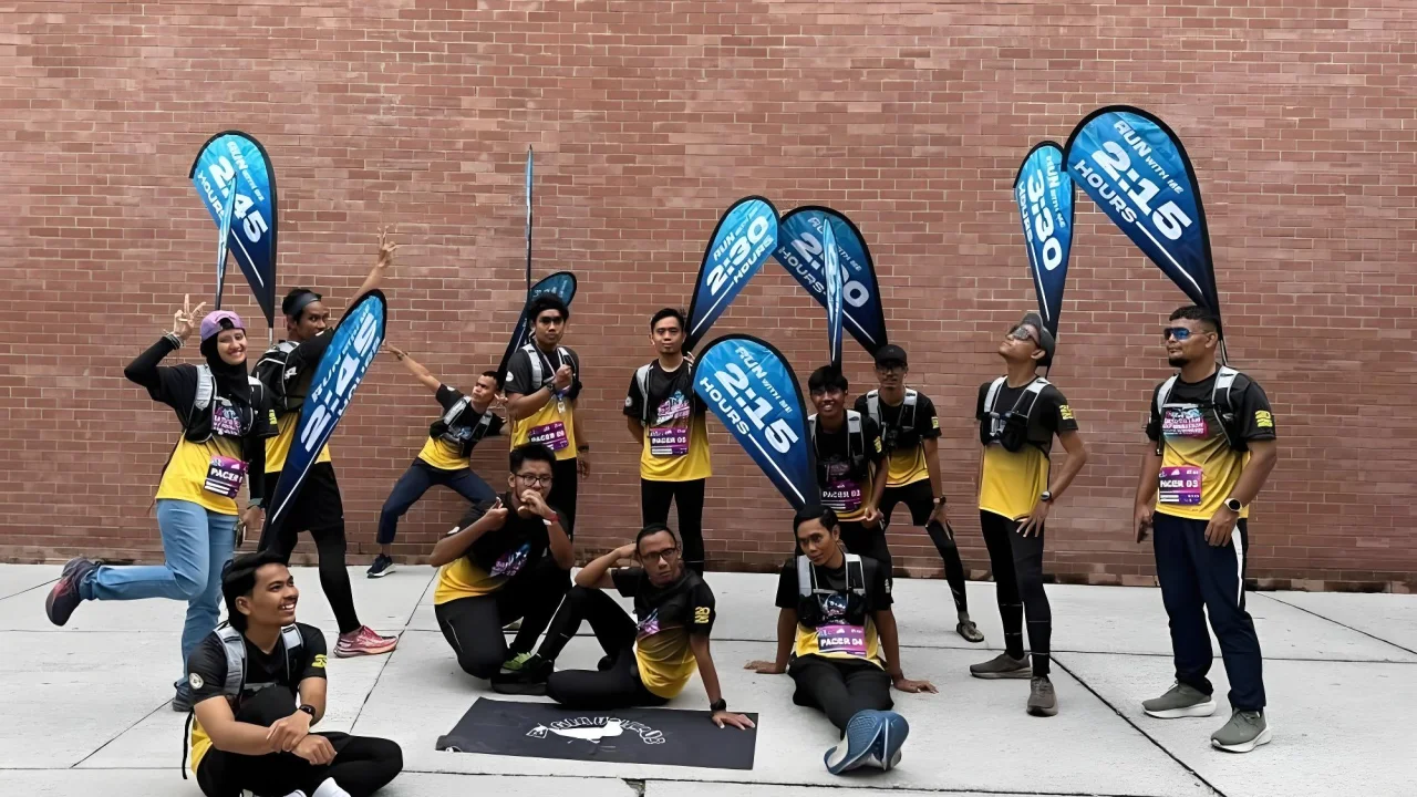 Group of runners holding 2:15 hour pacer flags attached to specialized marathon flag backpacks.