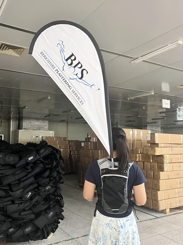Close-up of a marathon pacer backpack with a detachable white teardrop flag in a storage facility.