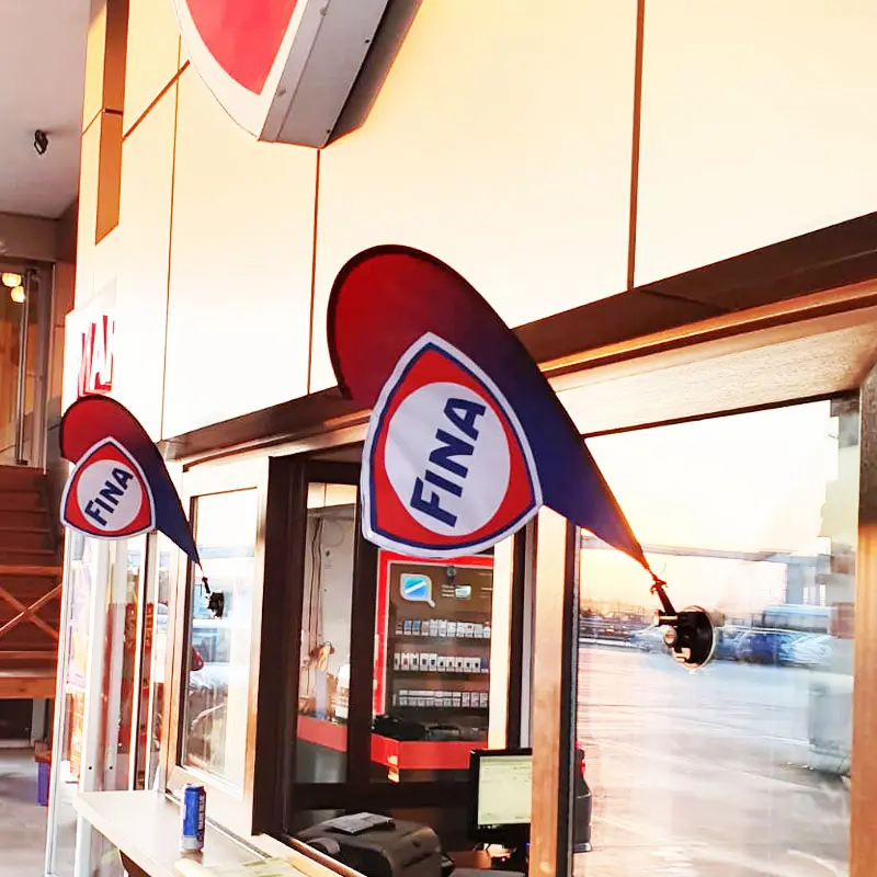 Red and blue FINA-branded triangular suction cup flags mounted on a sales window at a sports event venue