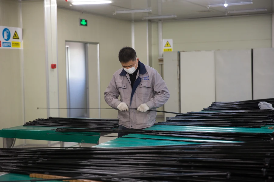 QC technician inspecting carbon fiber flagpole raw materials to prevent defects before production starts