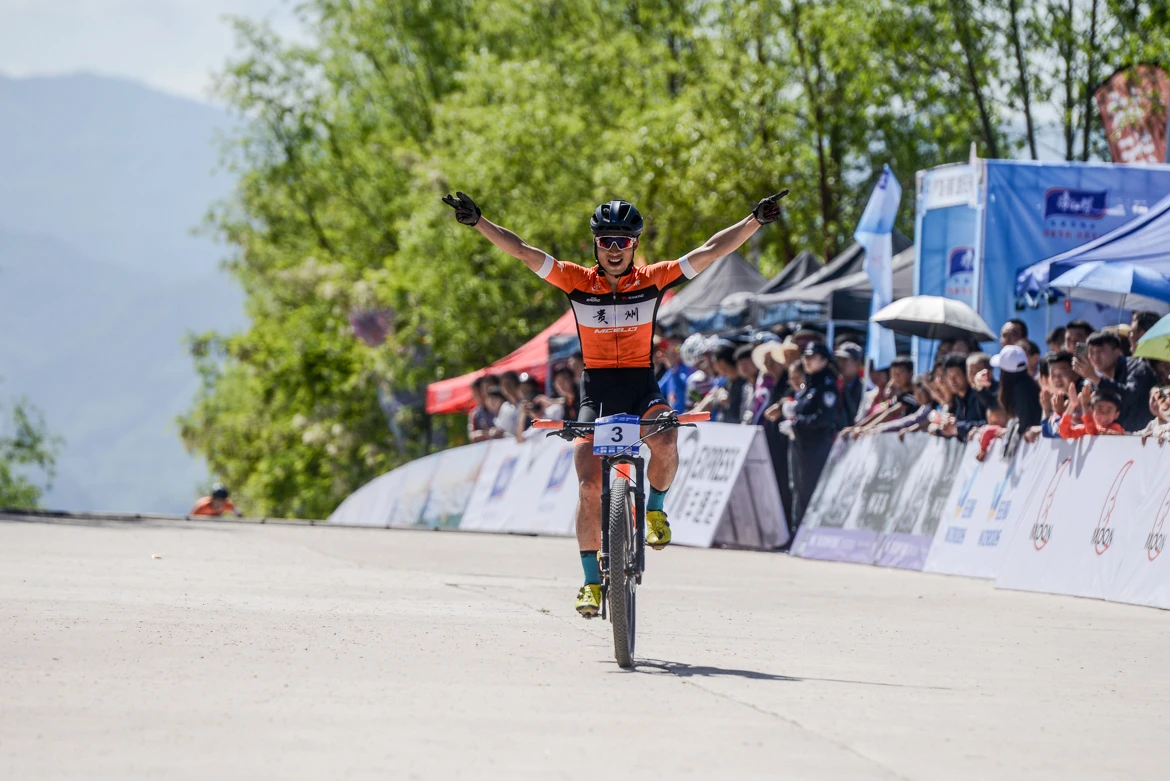 2019 china mountain bike open image-10 Winner celebrates with WZRODS flags visible in background crowd area