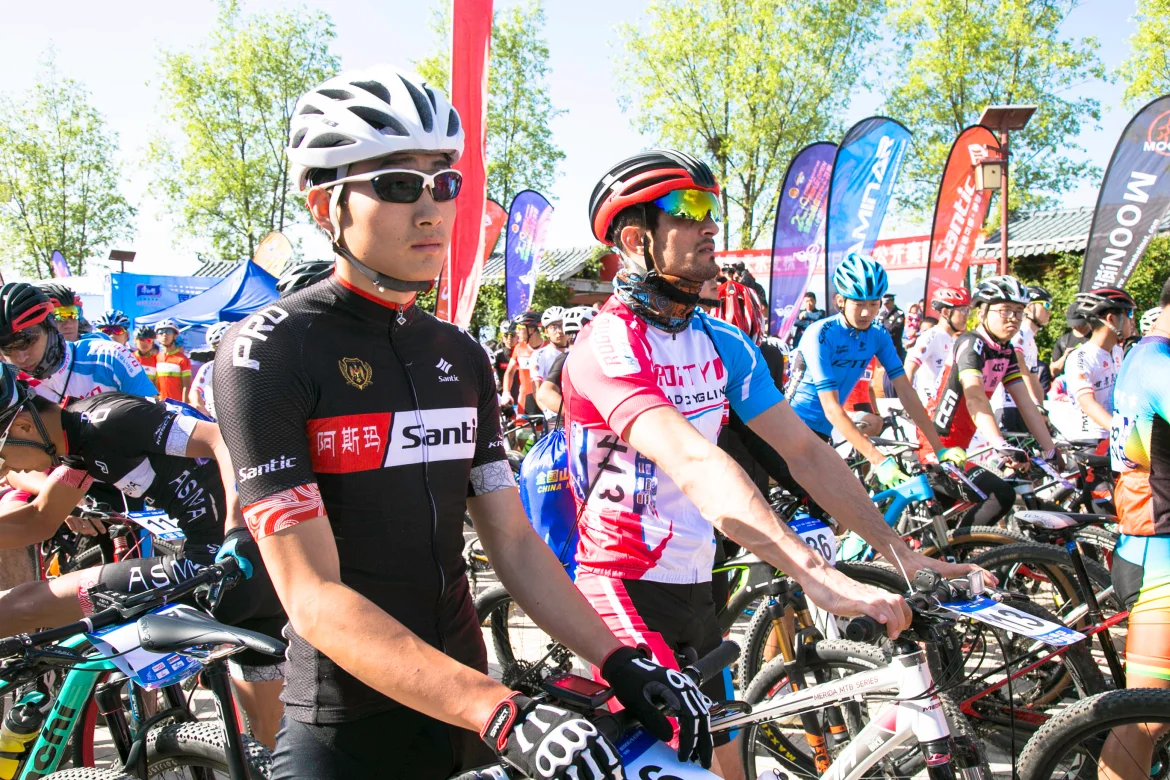 2019 china mountain bike open image-6 Cyclists in branded gear with WZRODS flags visible at race starting line