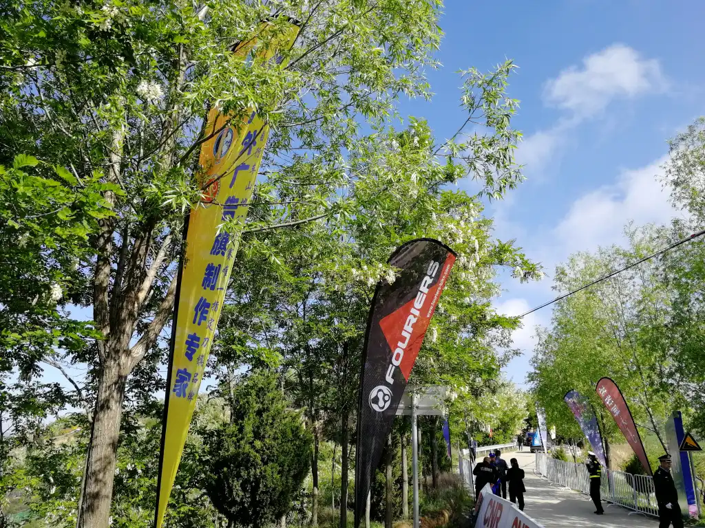 2019 china mountain bike open image-9 WZRODS partner FOURIERS teardrop flags lining tree-shaded event pathway