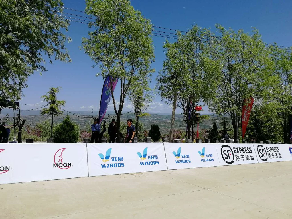 2019 china mountain bike open image-5 WZRODS teardrop flags near sponsor tents under mountain skies during cycling competition