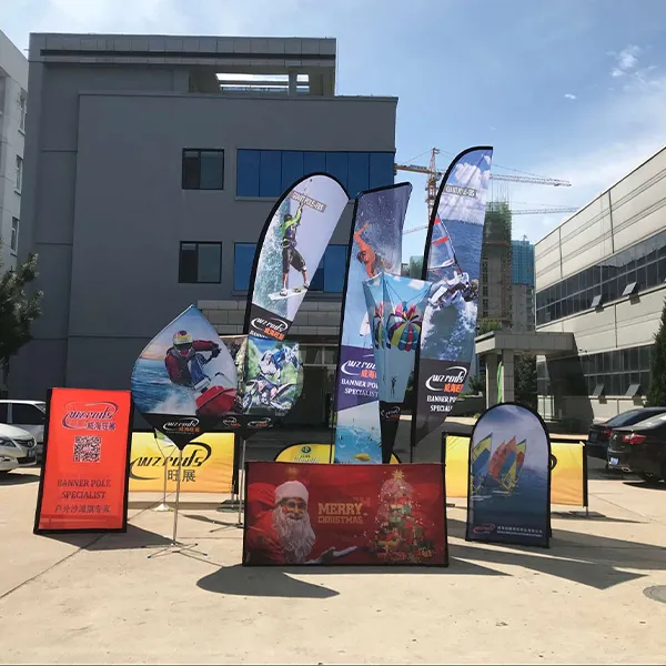 户外广告旗展示区,多种形状与图案的广告旗错落有致,色彩鲜艳,吸引眼球,背景为现代建筑与停车场。 多种形状的广告旗展示,A屏/豆旗、GT超大方/羽毛/沙滩旗、门型围挡、酒杯形,图案涵盖运动场景和节日主题,颜色丰富,背景为公司建筑。