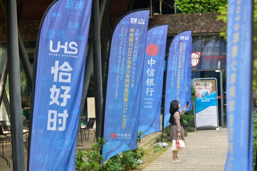Feather flags with sponsor logos displayed at a China junior tennis event entrance