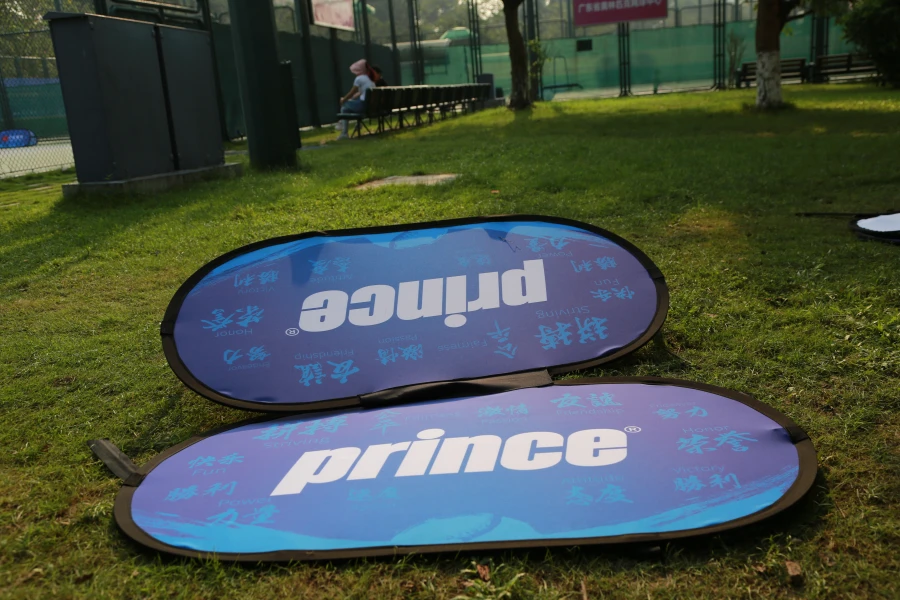 Blue 'prince' sideline banner on grass, showcasing brand visibility in an outdoor setting.